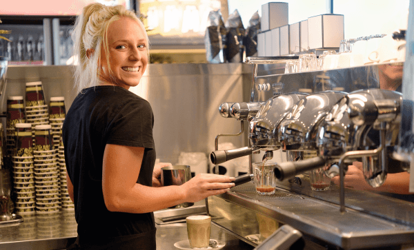 Young female barista smiling